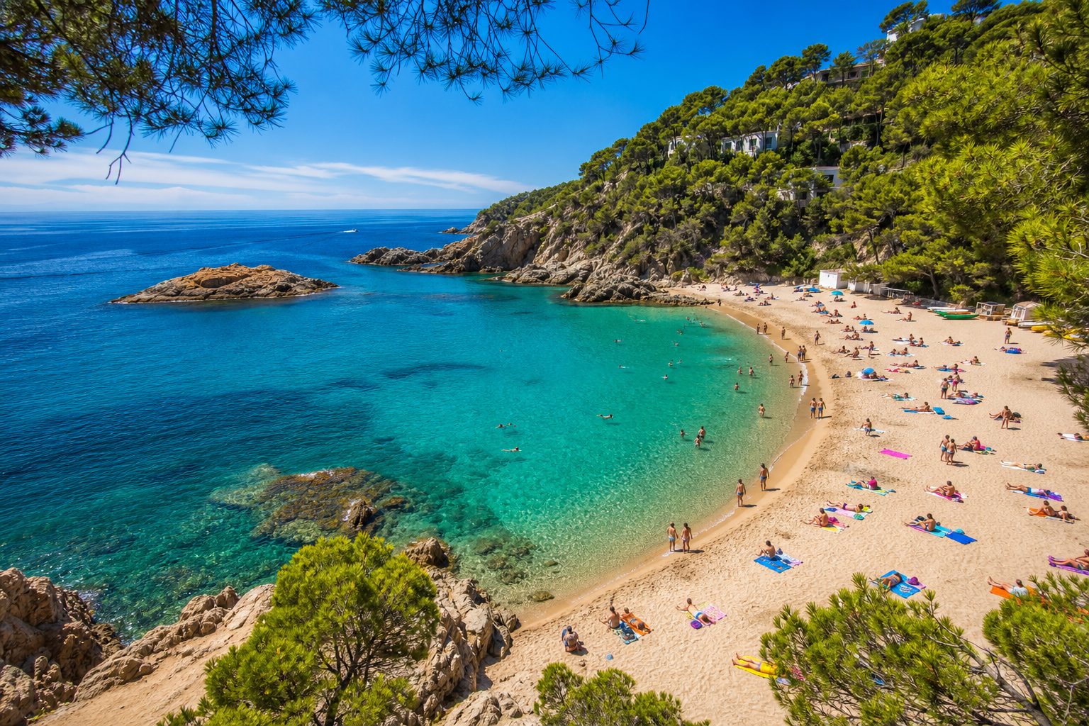 A cove on the Spanish coast, turquoise water and a busy sand beach ringed by pines